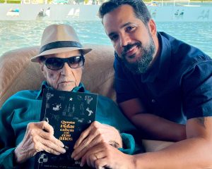 Rafael Ferrer e seu avô Saulo com o livro "Quantas vidas cabem em 100 anos".